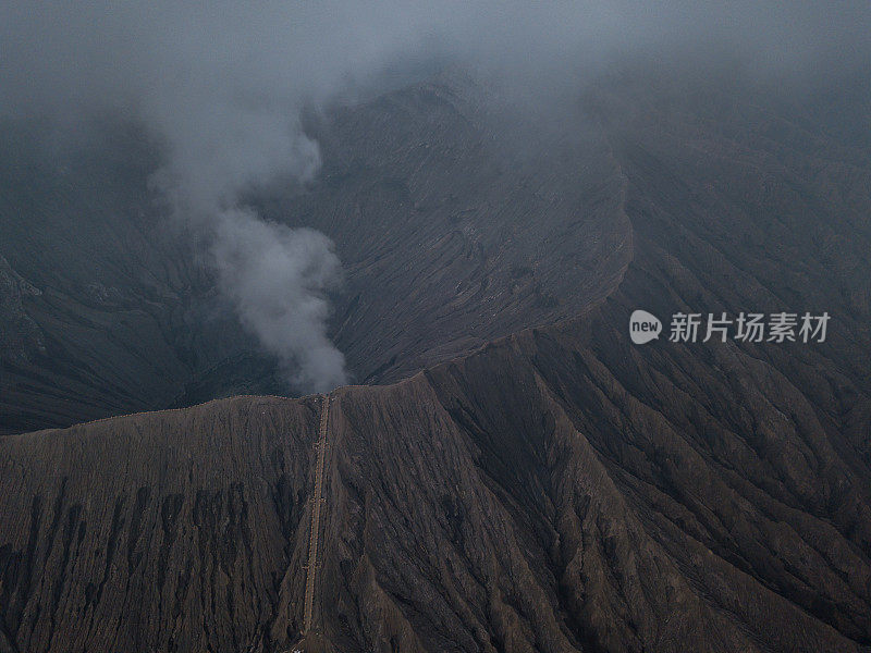 无人机鸟瞰图的Bromo火山口边缘与蒸汽在Bromo山国家公园在Cemoro Lawang村-东爪哇，印度尼西亚，亚洲。旅游目的地冒险的自然概念